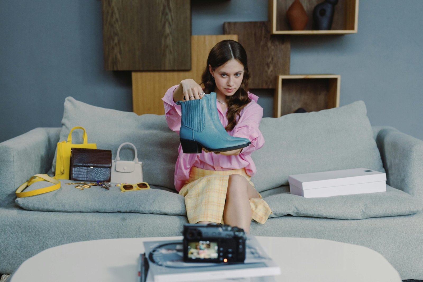 Young woman showcasing a stylish blue boot in an indoor setting.